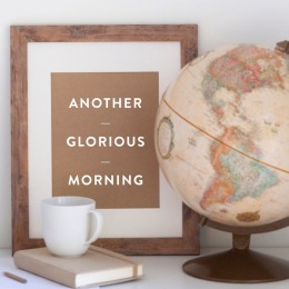 a globe, drink, book and sign on a table