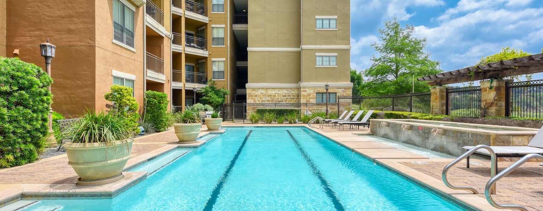 a swimming pool with chairs and plants