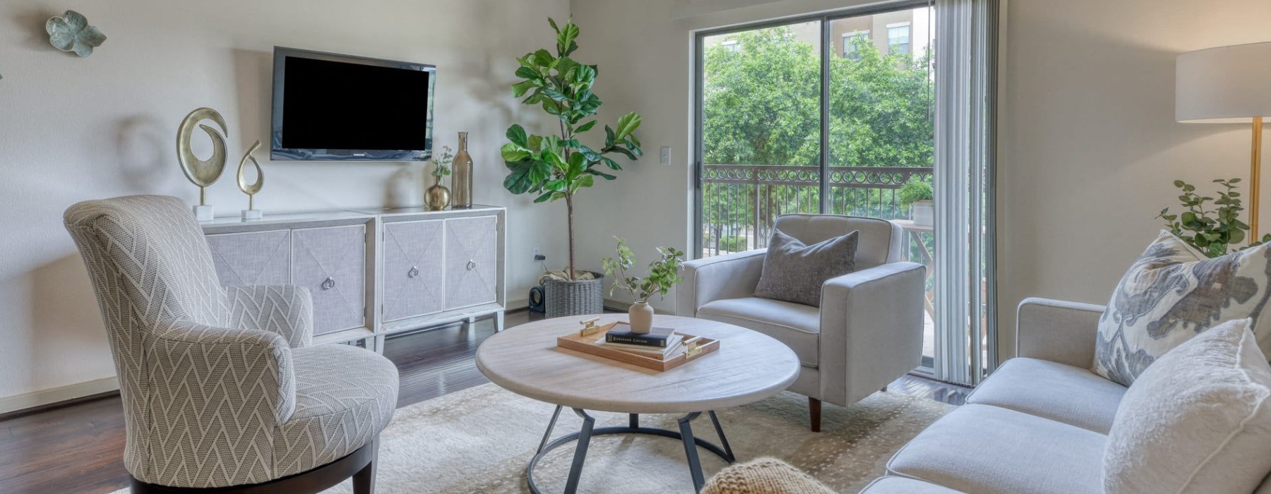 a living room with a tv, couch and chairs