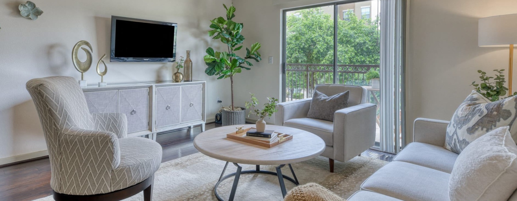 a living room with a tv, couch and chairs